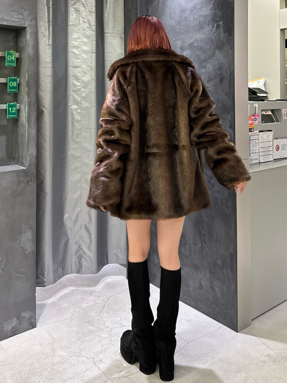 ブラウン系のその他アウター、ブルー系のスカート、ブラック系のブーツを着用したレディースの秋コーディネートの3枚目の写真