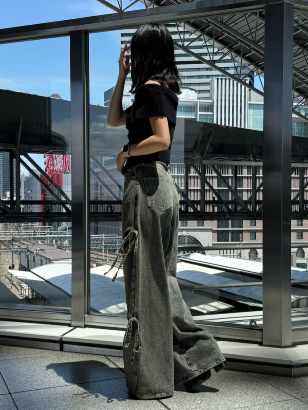 ブラック系のサンダル、ブルー系のデニムパンツ、ブラック系のニット/セーターを着用したレディースの夏コーディネートの2枚目の写真