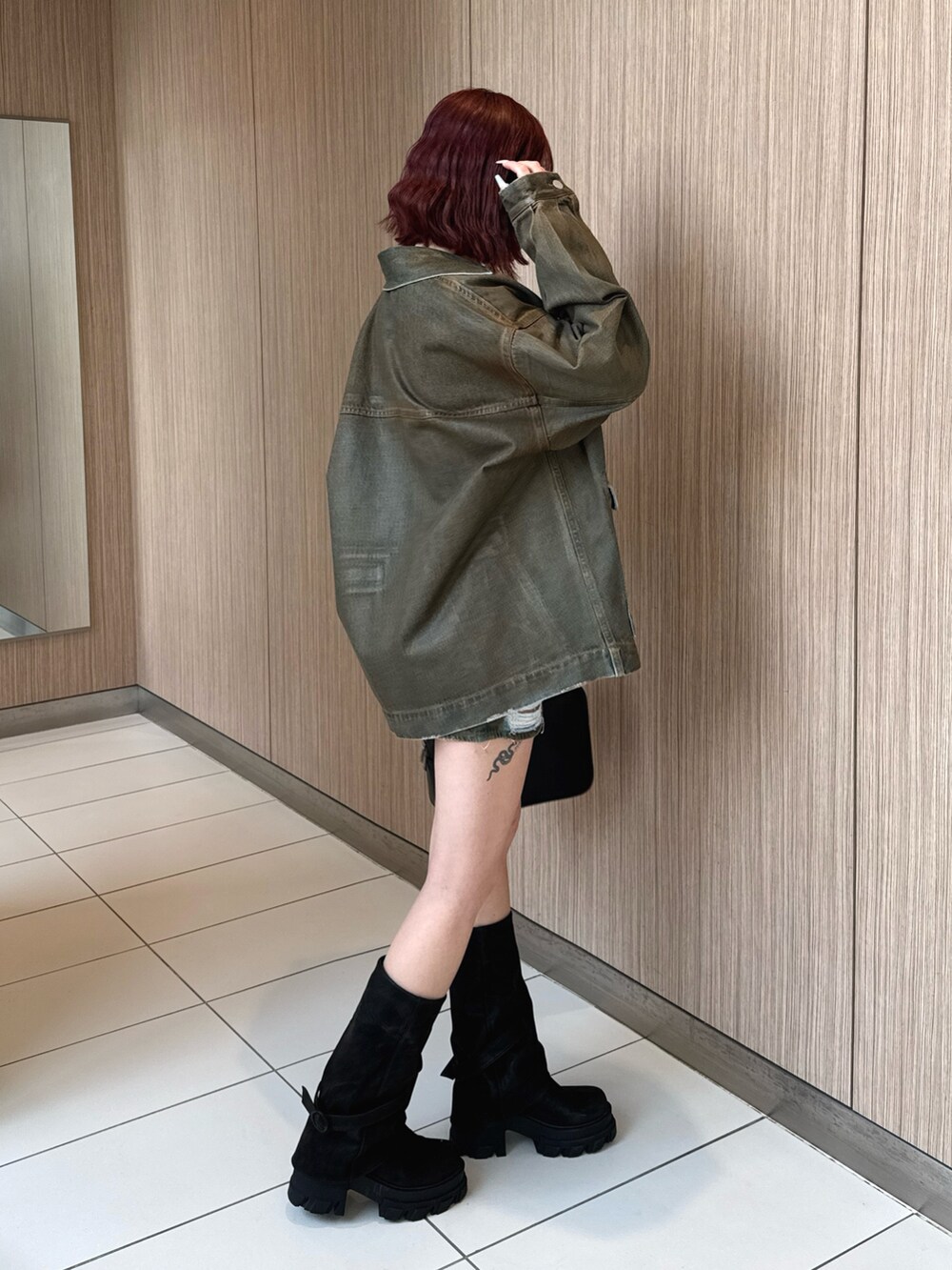 ブラウン系のブルゾン、ホワイト系のニット/セーター、ブラウン系のスカートを着用したレディースの冬コーディネートの2枚目の写真