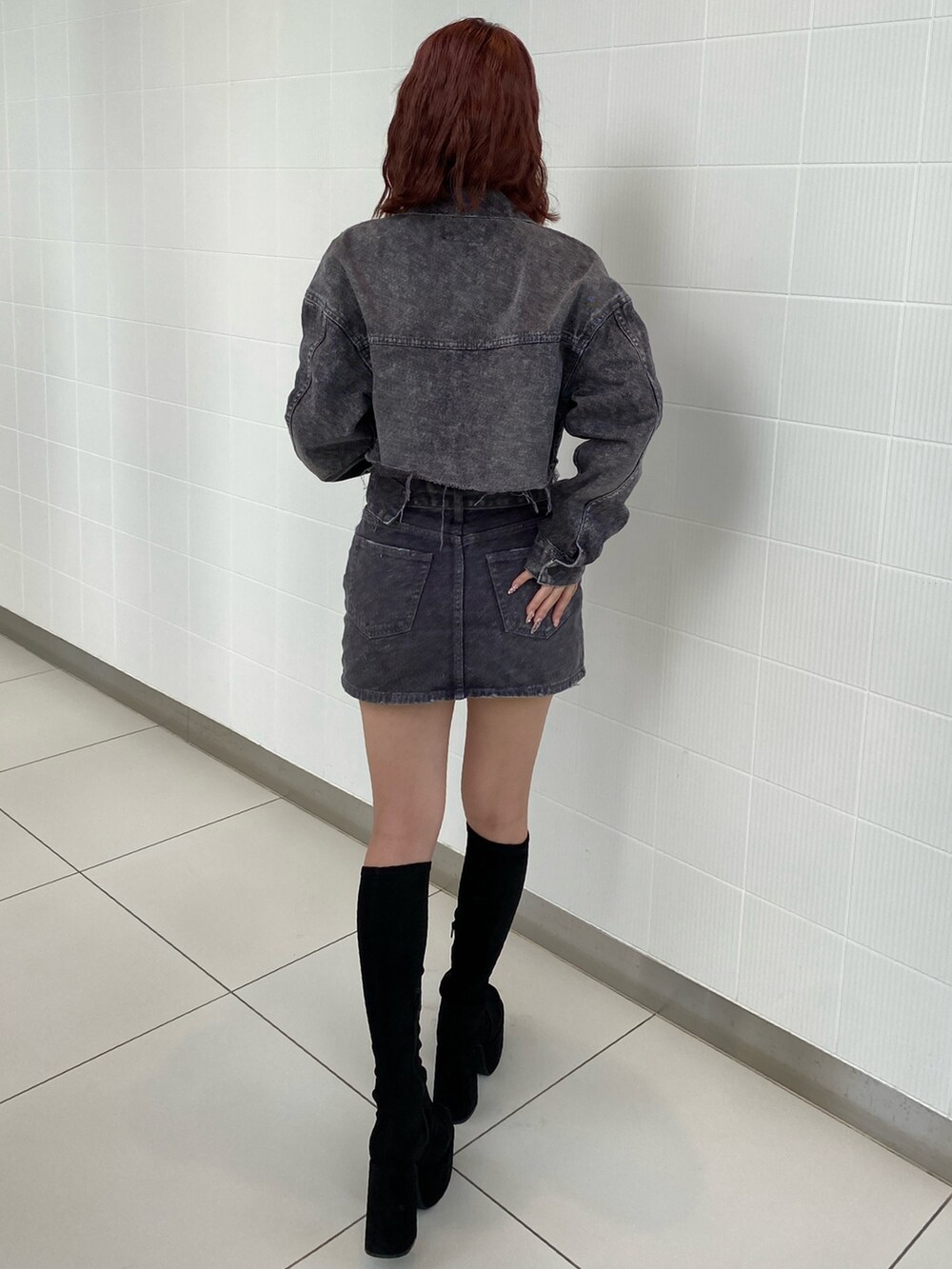 ブラック系のデニムジャケット、ブラック系のデニムスカート、その他のブーツを着用したレディースの秋コーディネートの2枚目の写真