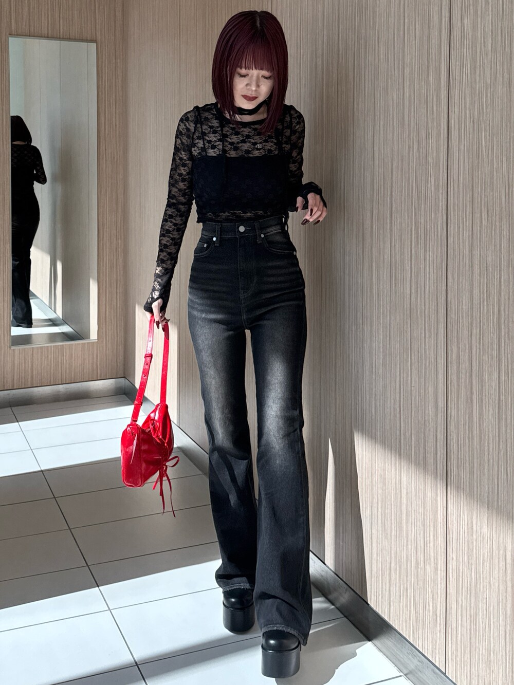 ブラック系のTシャツ/カットソー、ブラック系のデニムパンツ、レッド系のショルダーバッグを着用したレディースの秋コーディネートの5枚目の写真