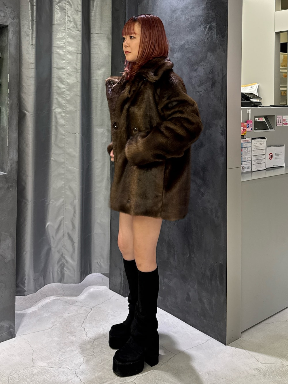 ブラウン系のその他アウター、ブルー系のスカート、ブラック系のブーツを着用したレディースの秋コーディネートの2枚目の写真