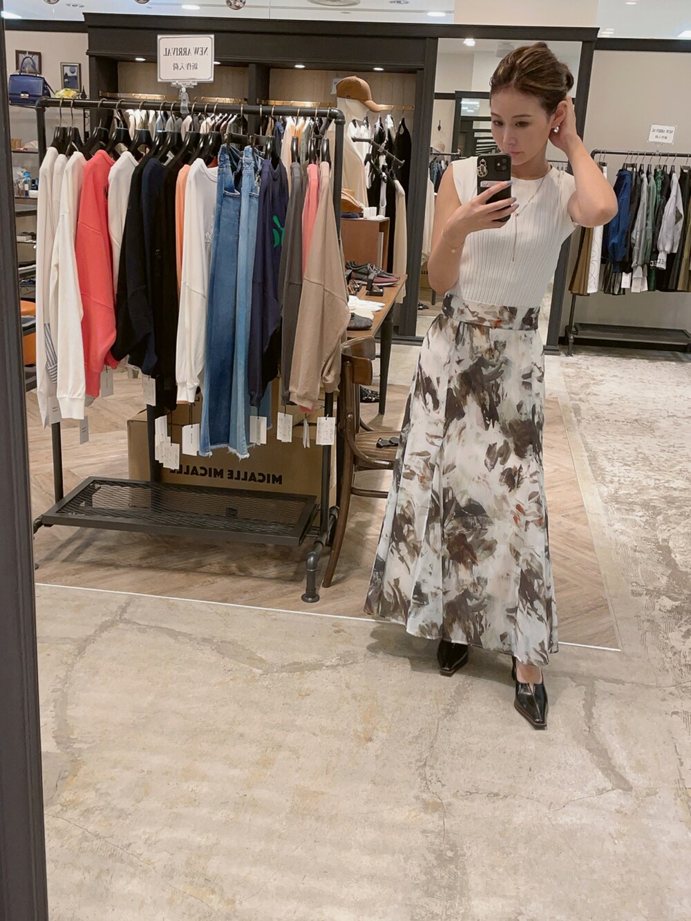 ホワイト系のスカート、ホワイト系のタンクトップ、ブラック系のパンプスを着用したレディースの秋コーディネートの2枚目の写真