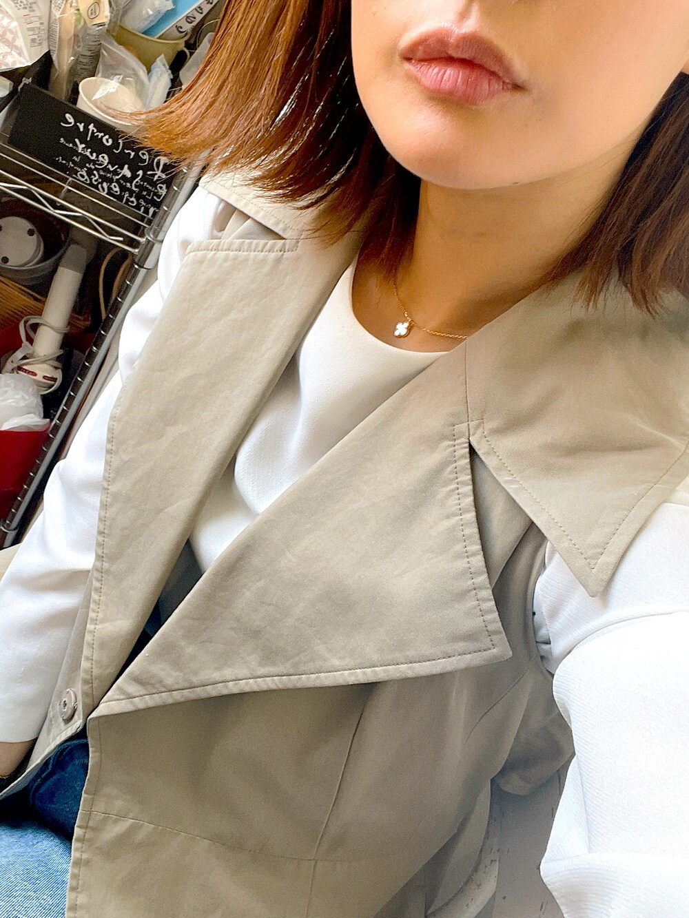 ベージュ系のベスト、ホワイト系のシャツ/ブラウス、ブルー系のデニムパンツを着用したレディースの秋コーディネートの3枚目の写真