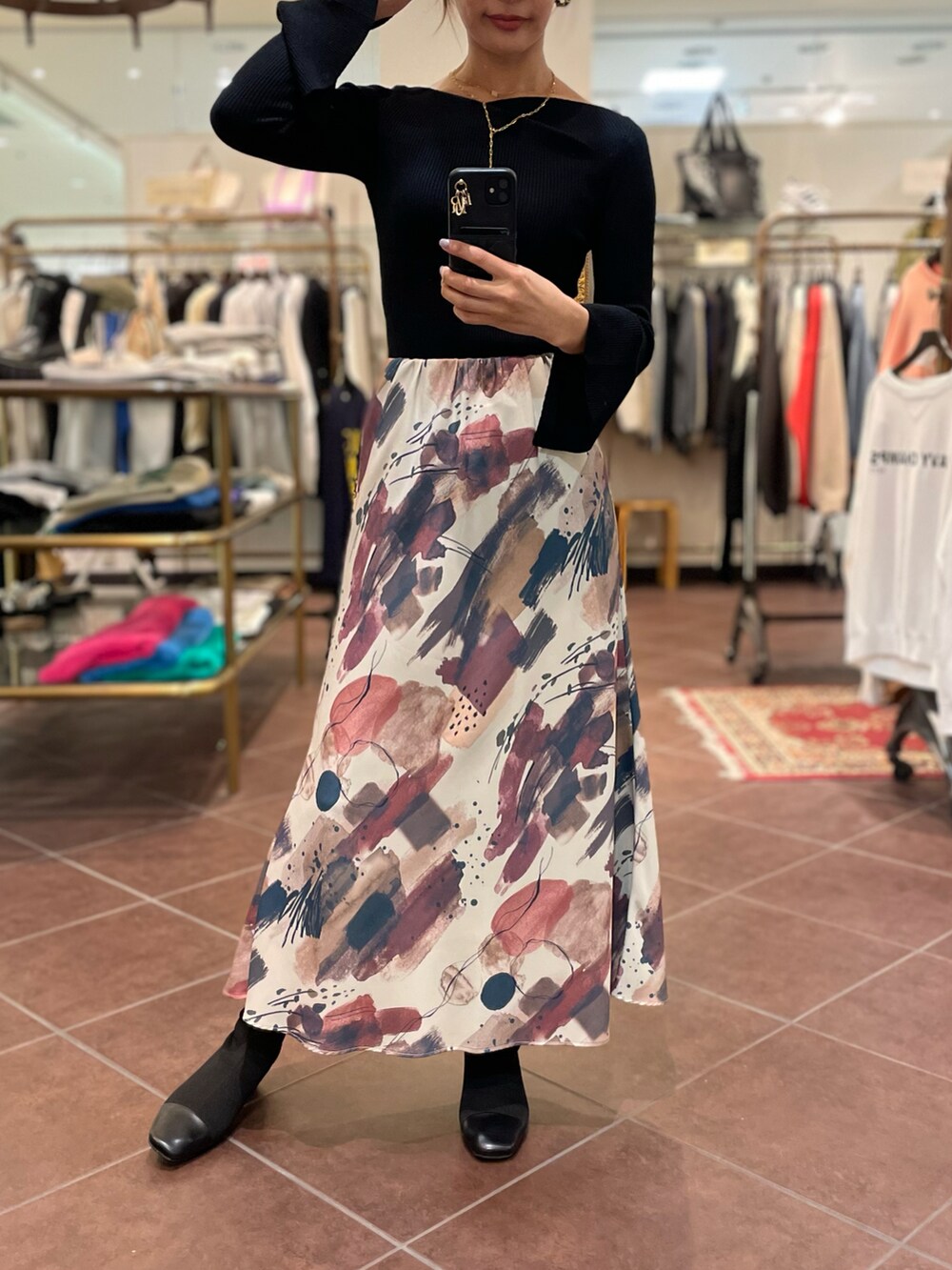 その他のスカート、ブラック系のブーツ、ブラック系のトップスを着用したレディースの秋コーディネートの2枚目の写真