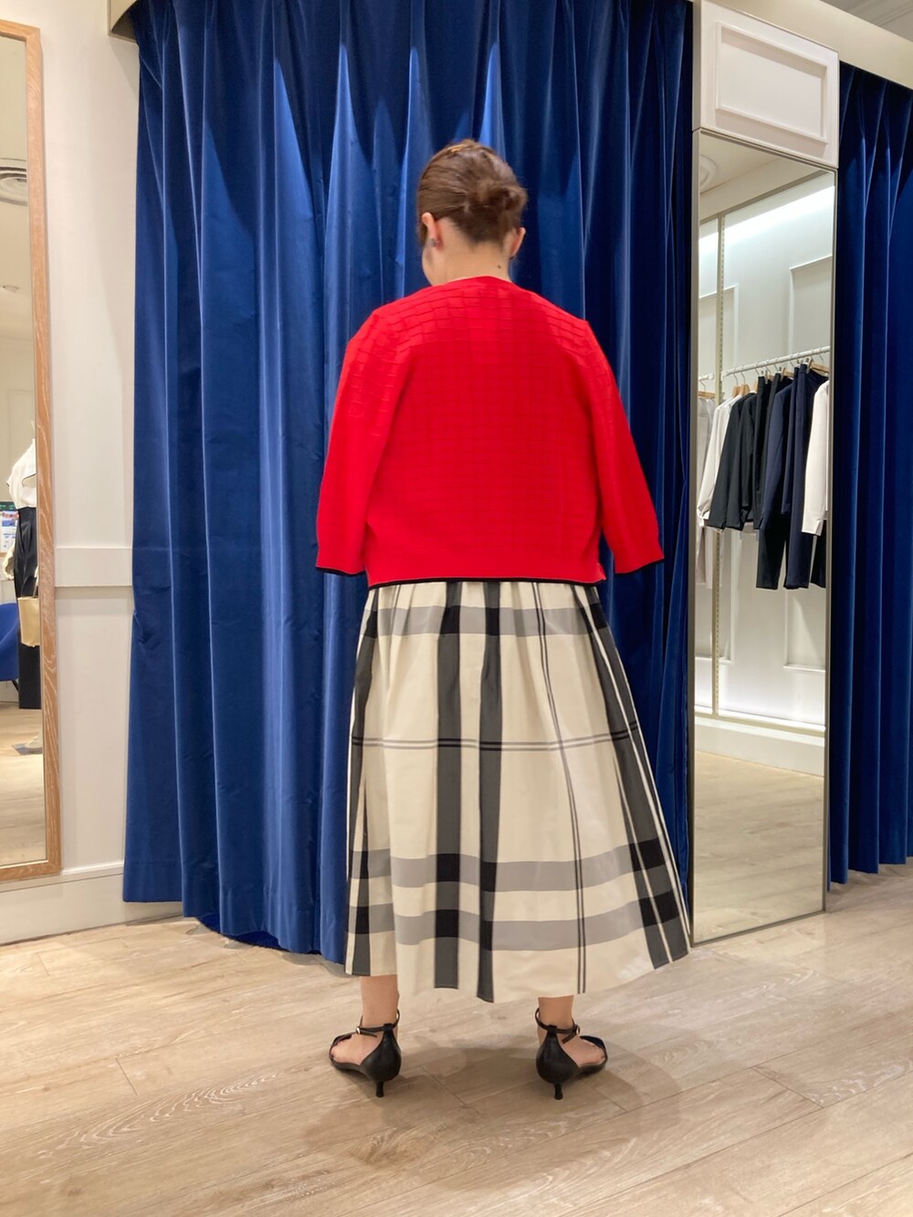 ベージュ系のスカート、ブラック系のTシャツ/カットソー、レッド系のカーディガン/ボレロを着用したレディースの春コーディネートの4枚目の写真