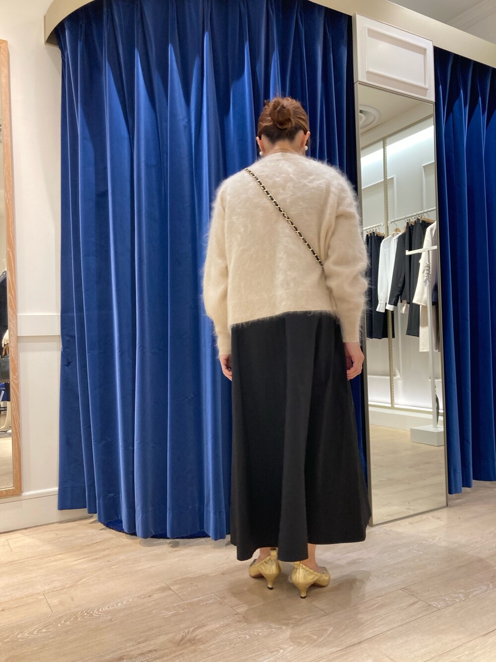 ブルー系のワンピース、ベージュ系のカーディガン/ボレロ、ゴールド系のニット/セーターを着用したレディースの冬コーディネートの3枚目の写真