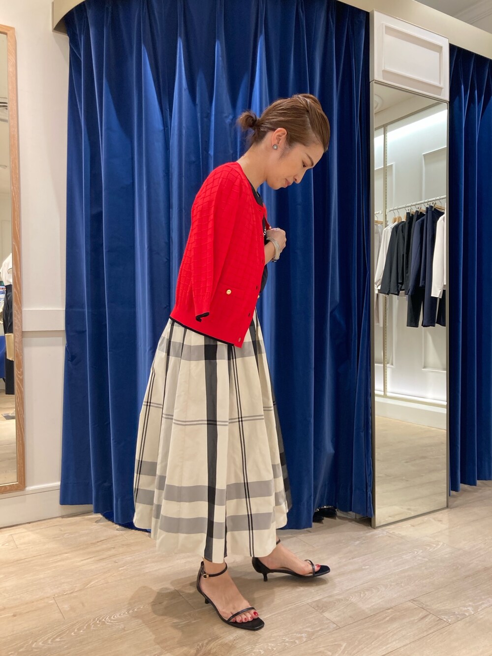 ベージュ系のスカート、ブラック系のTシャツ/カットソー、レッド系のカーディガン/ボレロを着用したレディースの春コーディネートの2枚目の写真