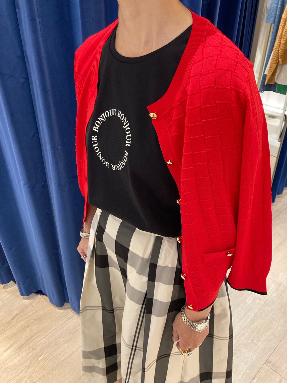 ベージュ系のスカート、ブラック系のTシャツ/カットソー、レッド系のカーディガン/ボレロを着用したレディースの春コーディネートの5枚目の写真