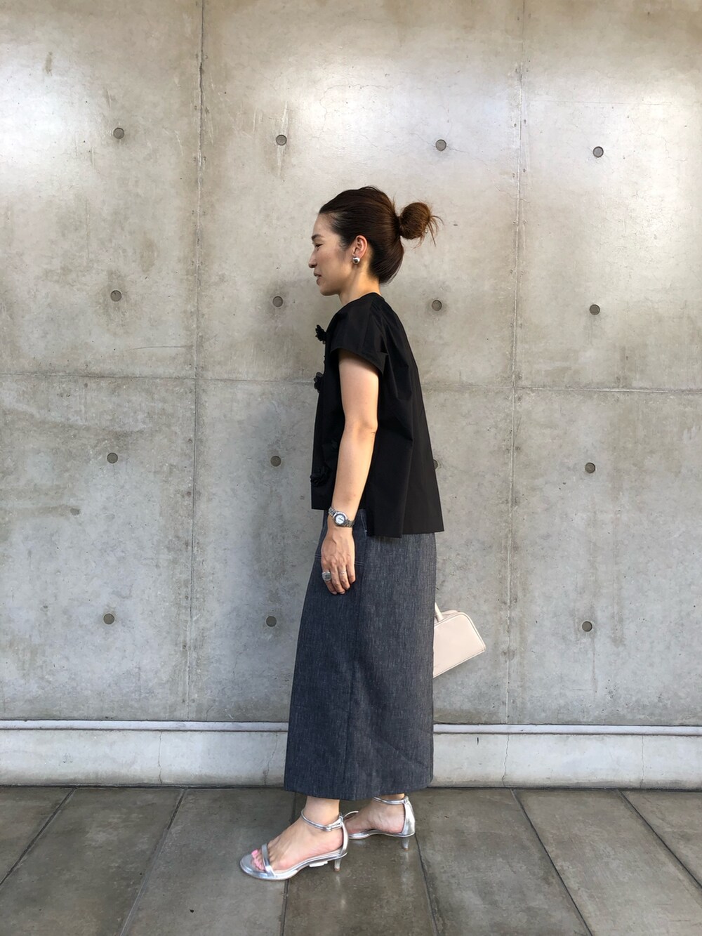 ブラック系のシャツ/ブラウス、ブルー系のスカート、ホワイト系のボストンバッグを着用したレディースの夏コーディネートの4枚目の写真