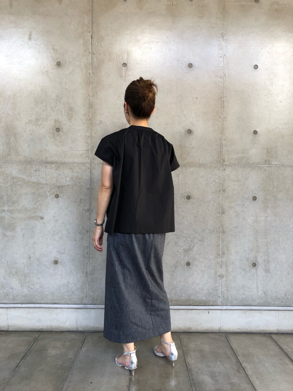 ブラック系のシャツ/ブラウス、ブルー系のスカート、ホワイト系のボストンバッグを着用したレディースの夏コーディネートの3枚目の写真