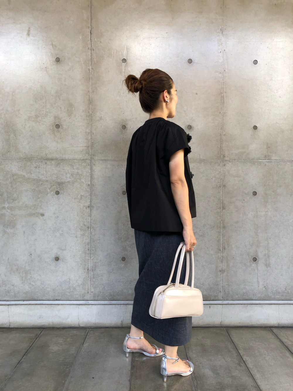 ブラック系のシャツ/ブラウス、ブルー系のスカート、ホワイト系のボストンバッグを着用したレディースの夏コーディネートの2枚目の写真