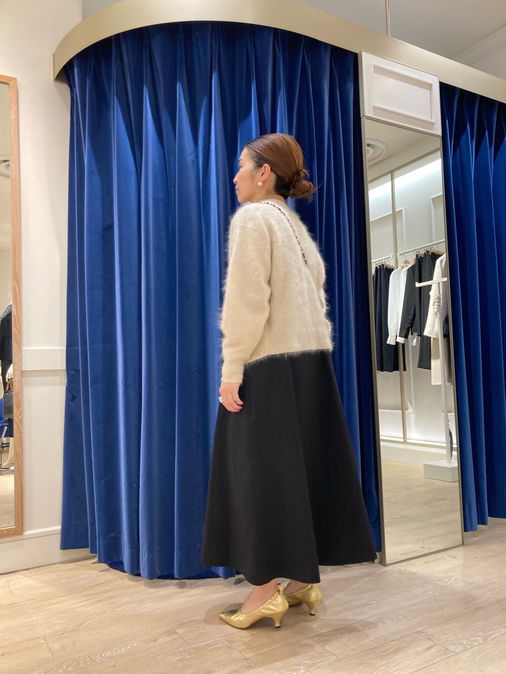 ブルー系のワンピース、ベージュ系のカーディガン/ボレロ、ゴールド系のニット/セーターを着用したレディースの冬コーディネートの4枚目の写真