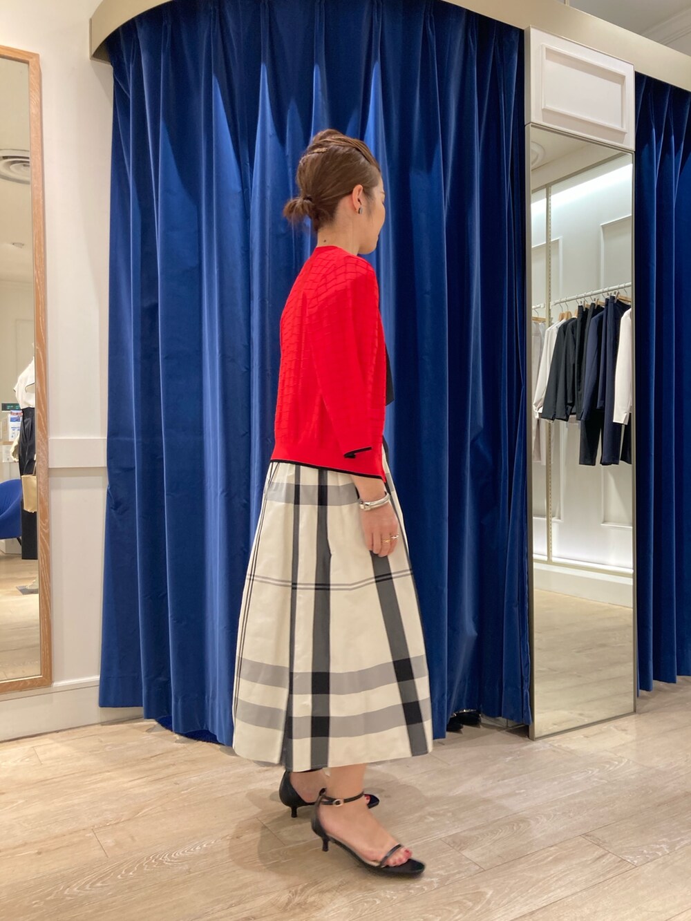 ベージュ系のスカート、ブラック系のTシャツ/カットソー、レッド系のカーディガン/ボレロを着用したレディースの春コーディネートの3枚目の写真