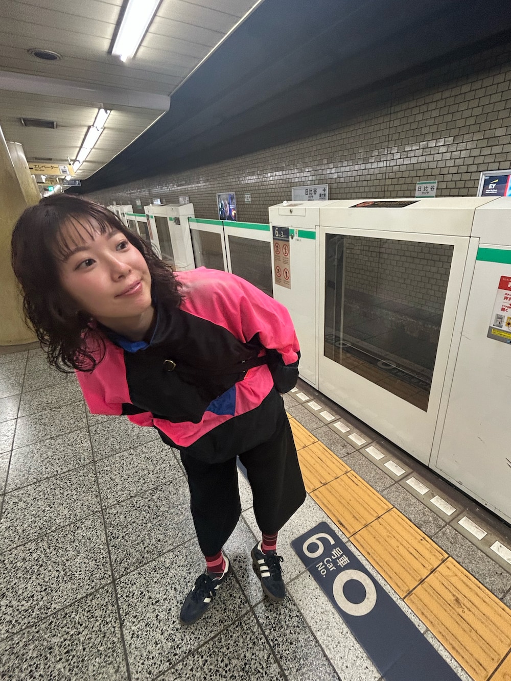 ブルー系のスニーカー、ブラック系のショルダーバッグ、ブラック系のナイロンジャケットを着用したレディースの秋コーディネートの2枚目の写真