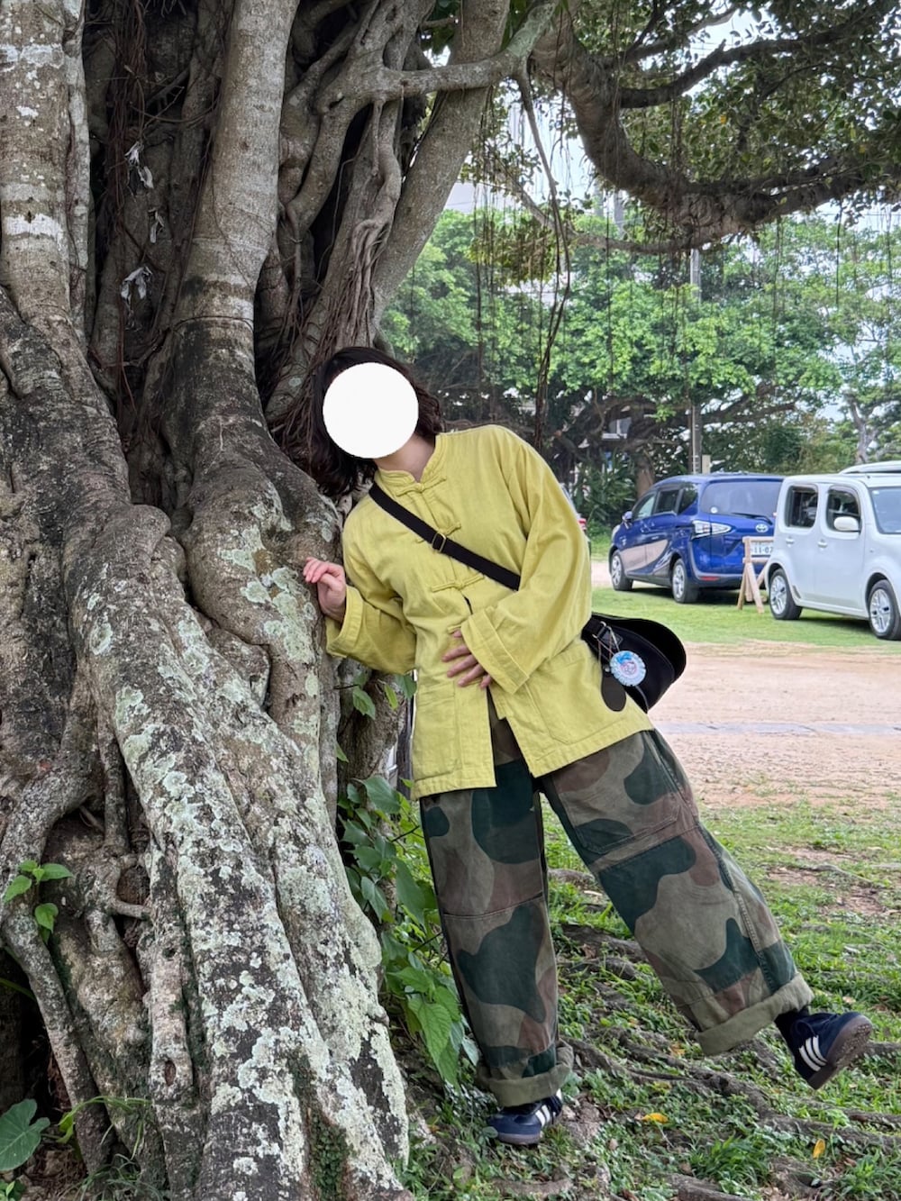 グリーン系のカーゴパンツ、ブルー系のスニーカー、ブラック系のショルダーバッグを着用したレディースの春コーディネートの2枚目の写真