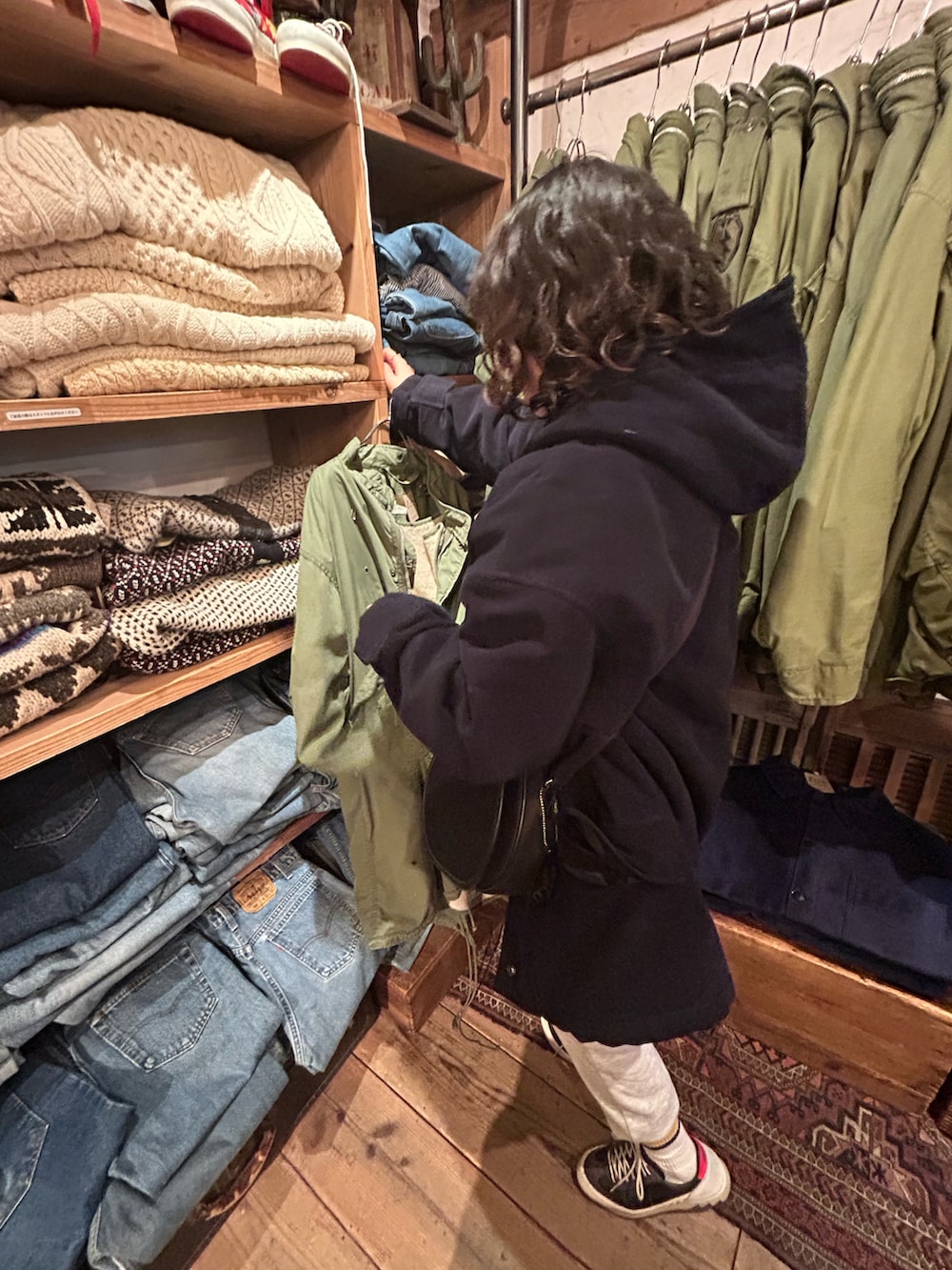 ブラック系のジャケット/アウター、ブラック系のスニーカー、ブラック系のショルダーバッグを着用したレディースの冬コーディネートの2枚目の写真