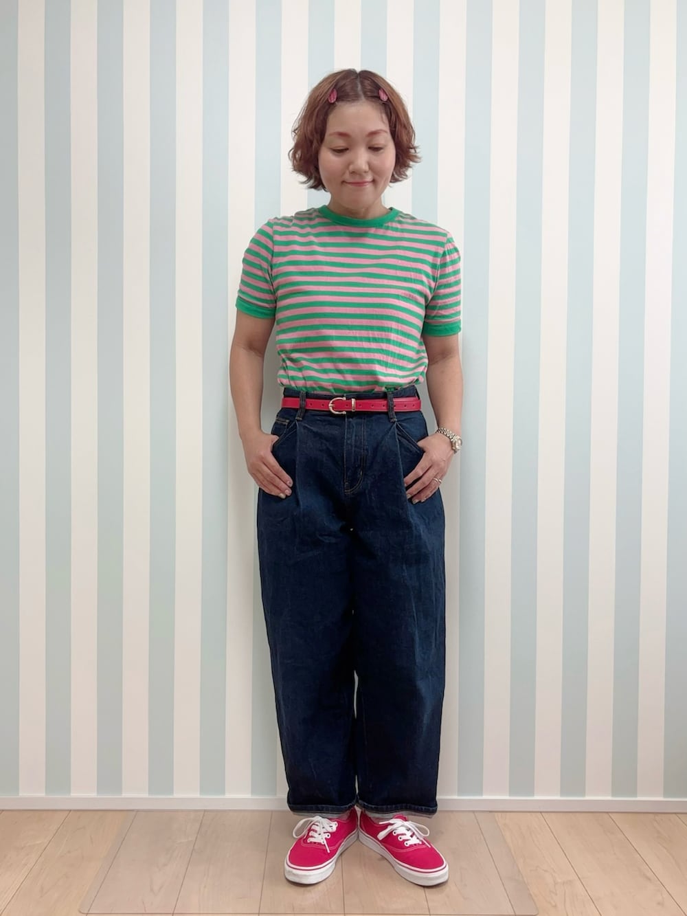 レッド系のスニーカー、グリーン系のTシャツ/カットソー、ブルー系のデニムパンツを着用したレディースの夏コーディネートの2枚目の写真