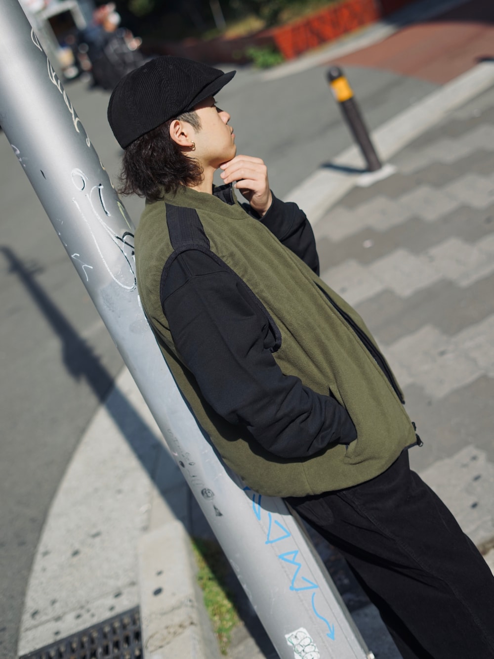 グリーン系のベスト、ブラック系のスウェット、ブラック系のその他パンツを着用したメンズの秋コーディネートの2枚目の写真