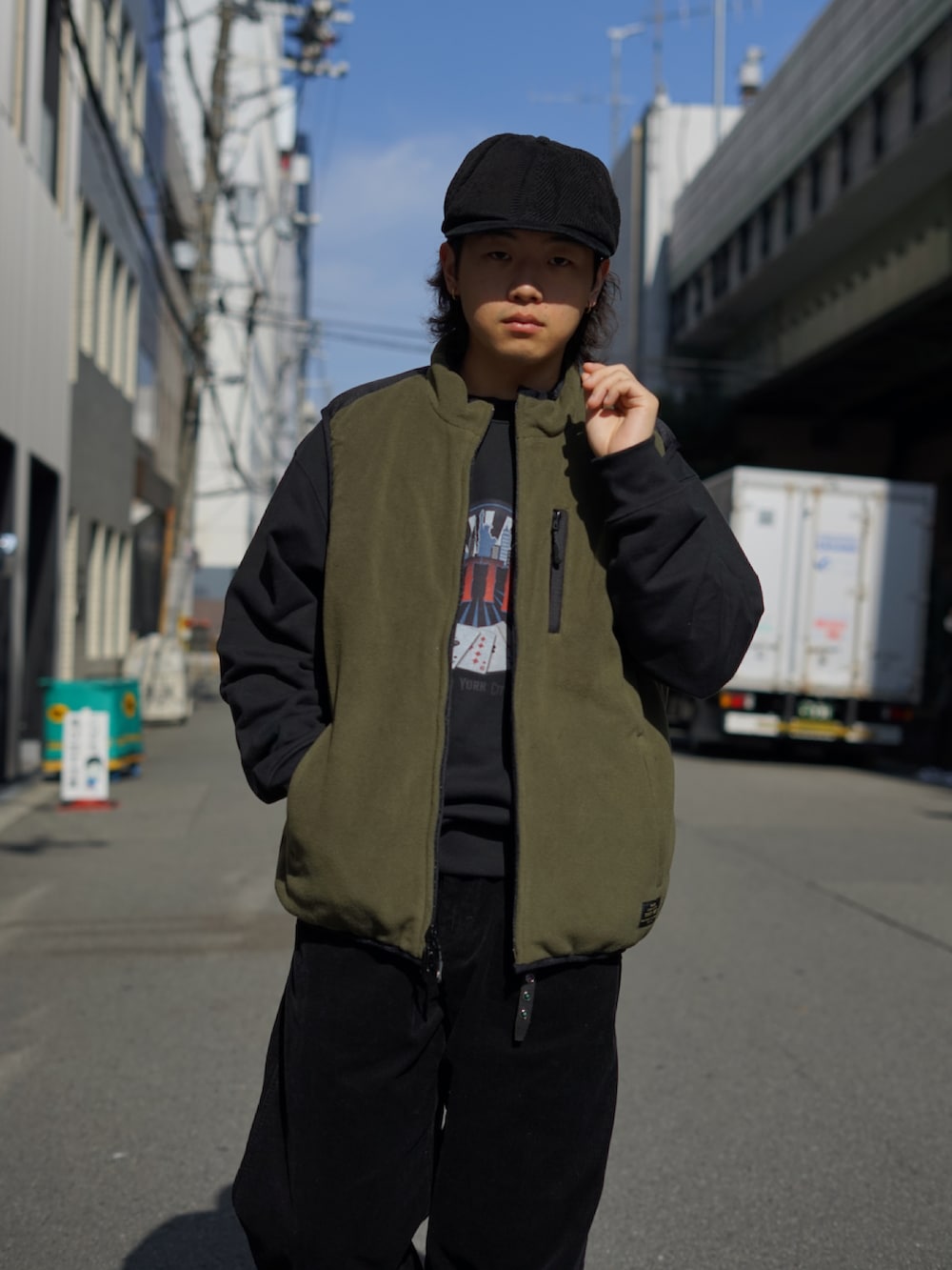 グリーン系のベスト、ブラック系のスウェット、ブラック系のその他パンツを着用したメンズの秋コーディネートの3枚目の写真