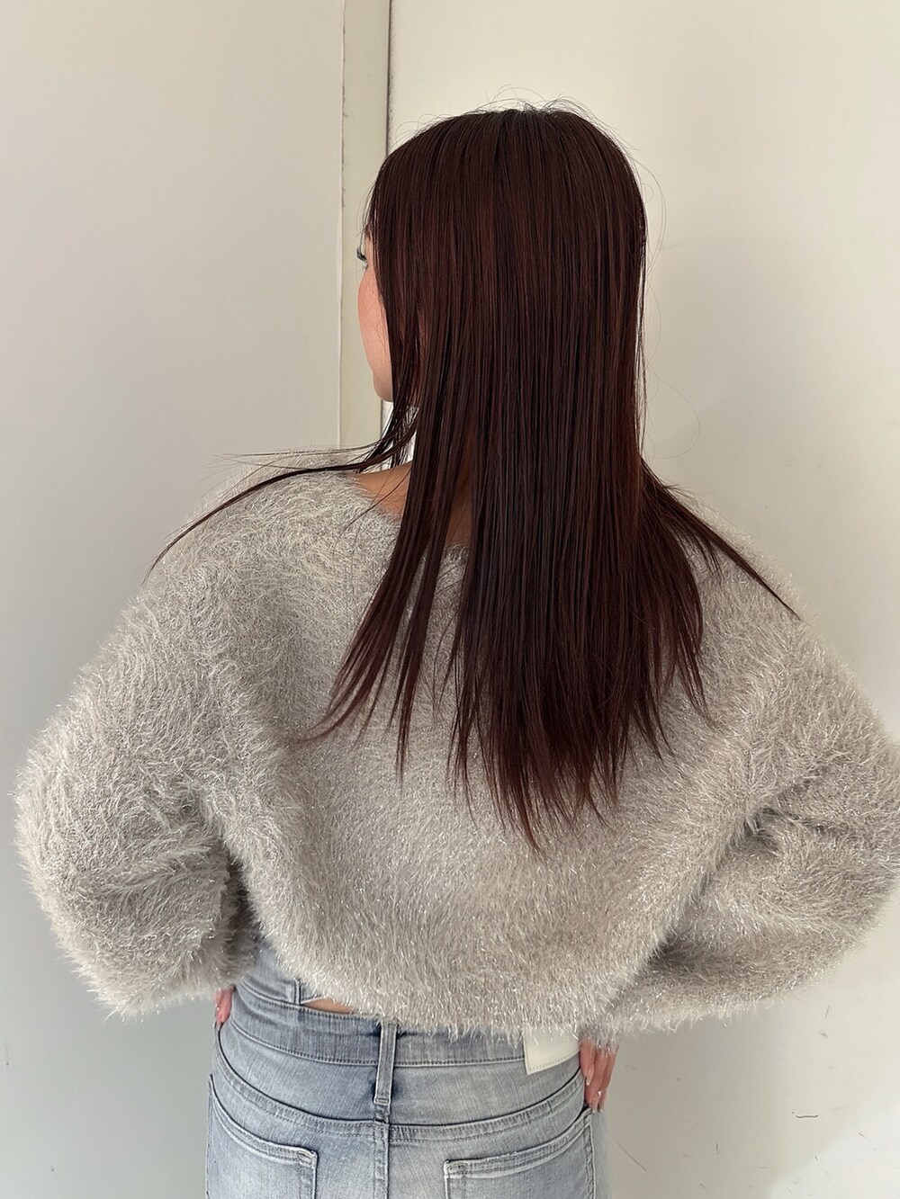 ブルー系のデニムパンツ、ホワイト系のパンプス、ベージュ系のカーディガン/ボレロを着用したレディースの秋コーディネートの6枚目の写真