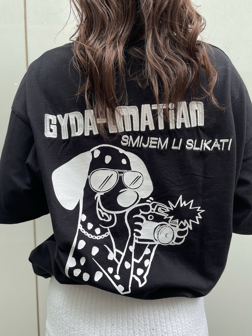 ブラック系のTシャツ/カットソー、ホワイト系のスカート、ホワイト系のサンダルを着用したレディースの春コーディネートの6枚目の写真