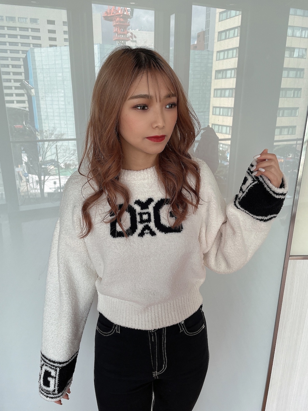 ホワイト系のニット/セーター、ブラック系のブルゾン、ブラック系のデニムパンツを着用したレディースの冬コーディネートの6枚目の写真