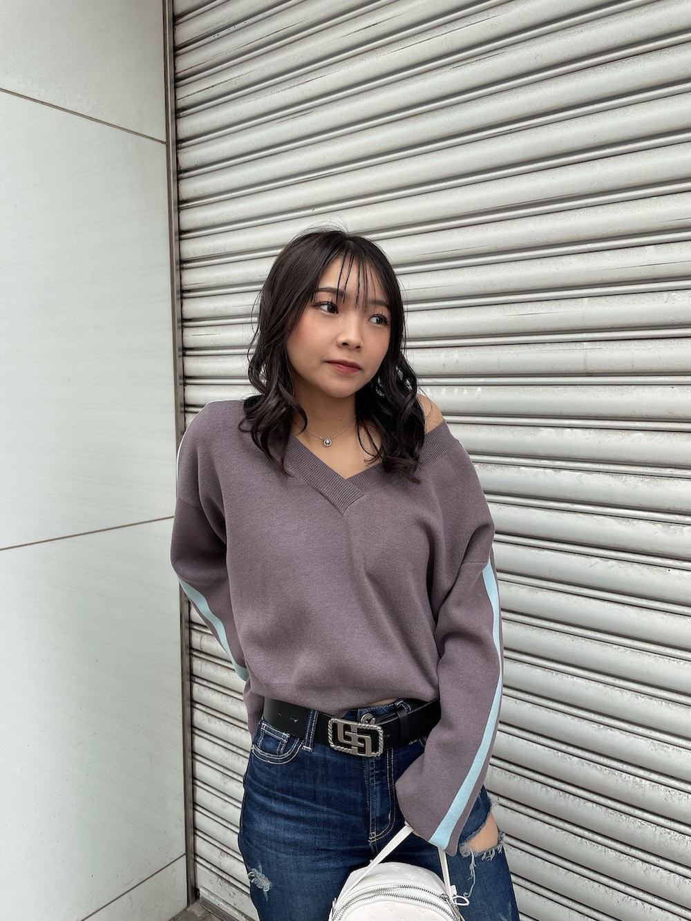 グレー系のニット/セーター、ブルー系のデニムパンツ、ブラック系のブーツを着用したレディースの冬コーディネートの3枚目の写真