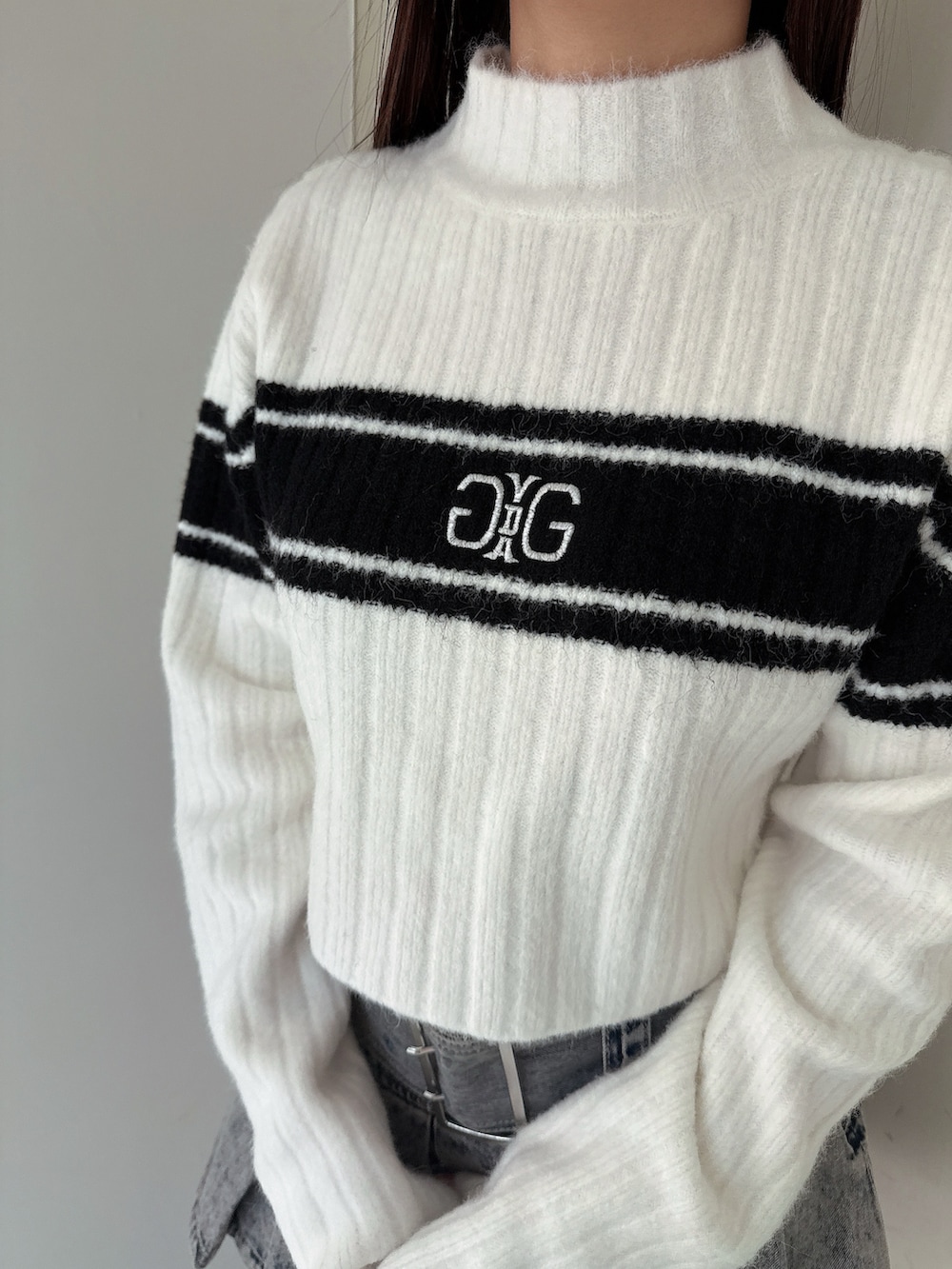 ブルー系のデニムスカート、ブラック系のブーツ、ホワイト系のニット/セーターを着用したレディースの冬コーディネートの7枚目の写真