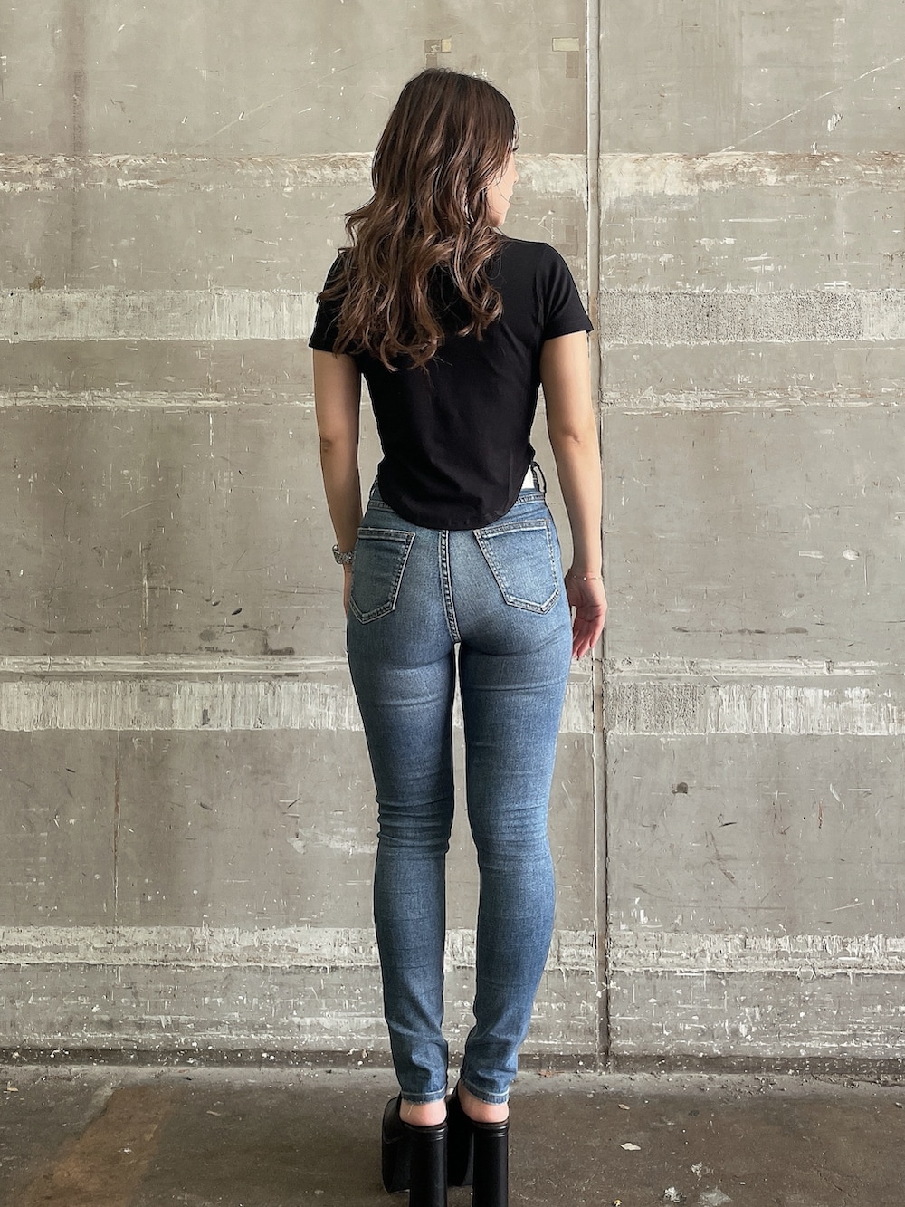 ブラック系のTシャツ/カットソー、ブルー系のデニムパンツ、ブラック系のサンダルを着用したレディースの夏コーディネートの3枚目の写真