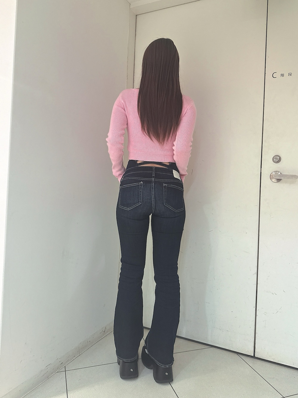 ブルー系のデニムパンツ、ブラック系のサンダル、ピンク系のニット/セーターを着用したレディースの春コーディネートの3枚目の写真