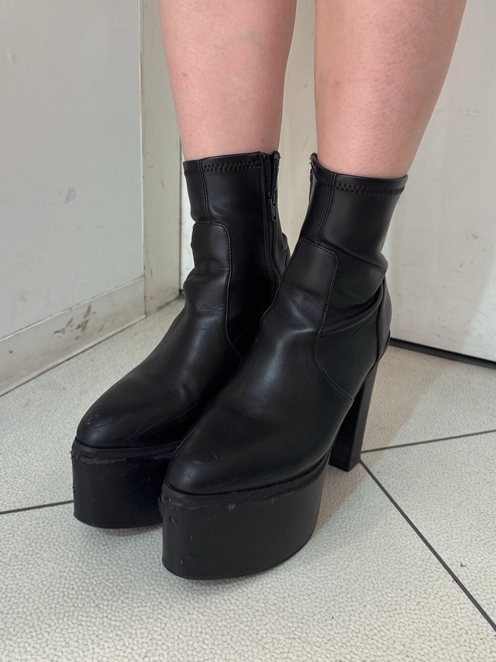 ブラック系のブーツ、ホワイト系のTシャツ/カットソー、ブラック系のデニムスカートを着用したレディースの秋コーディネートの9枚目の写真