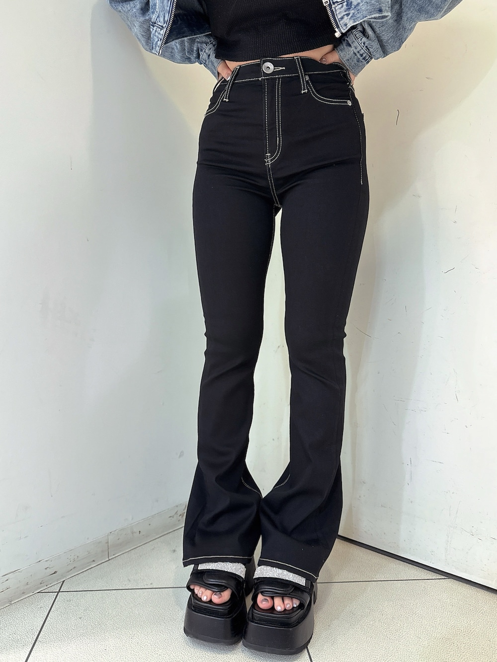 ブラック系のデニムパンツ、ブルー系のデニムジャケット、ブラック系のサンダルを着用したレディースの春コーディネートの8枚目の写真