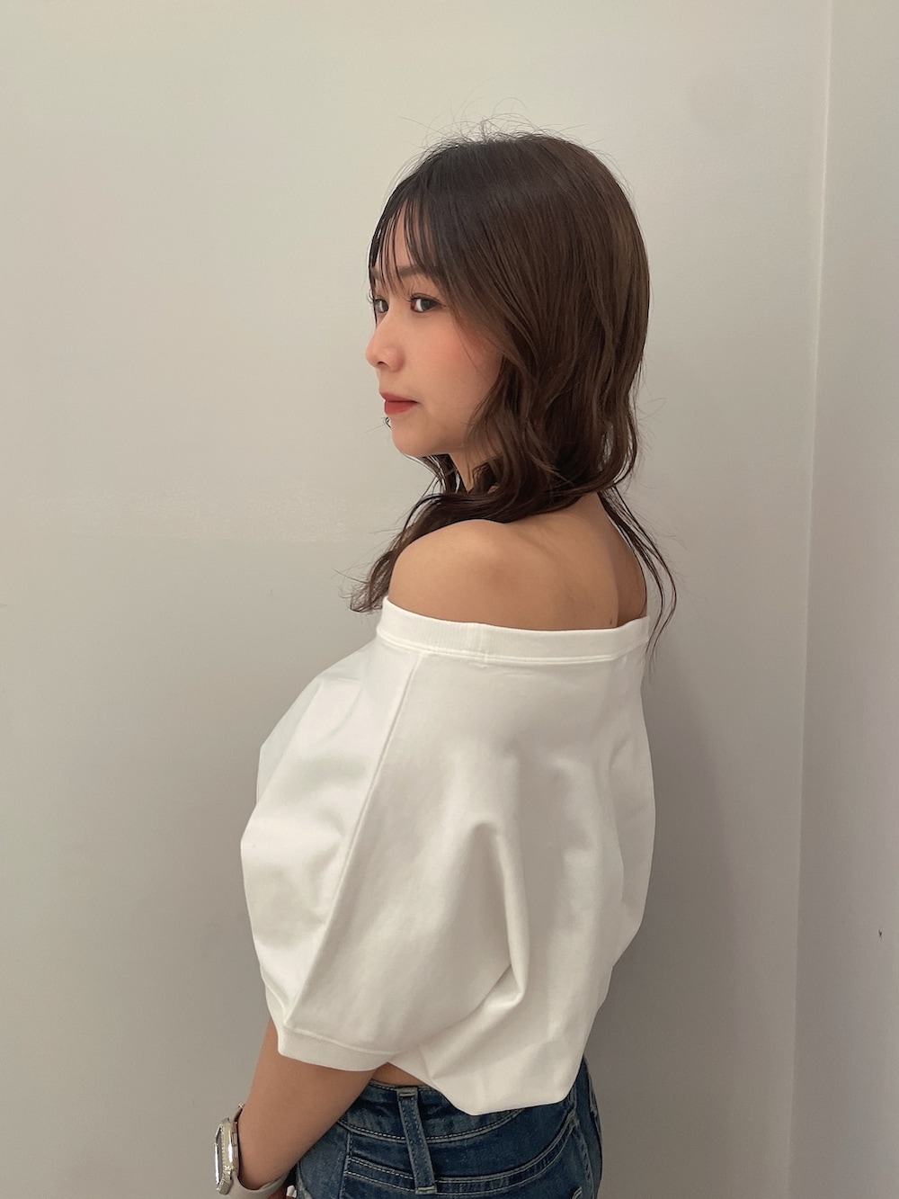 ホワイト系のTシャツ/カットソー、ブルー系のデニムパンツ、ブラック系のバックパック/リュックを着用したレディースの春コーディネートの5枚目の写真