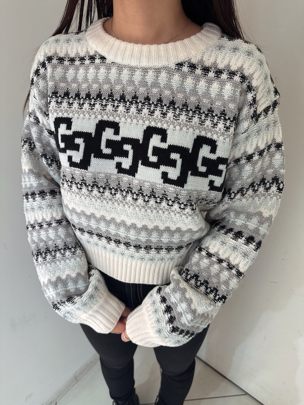 ブラック系のデニムパンツ、ブラック系のブーツ、ホワイト系のニット/セーターを着用したレディースの秋コーディネートの7枚目の写真