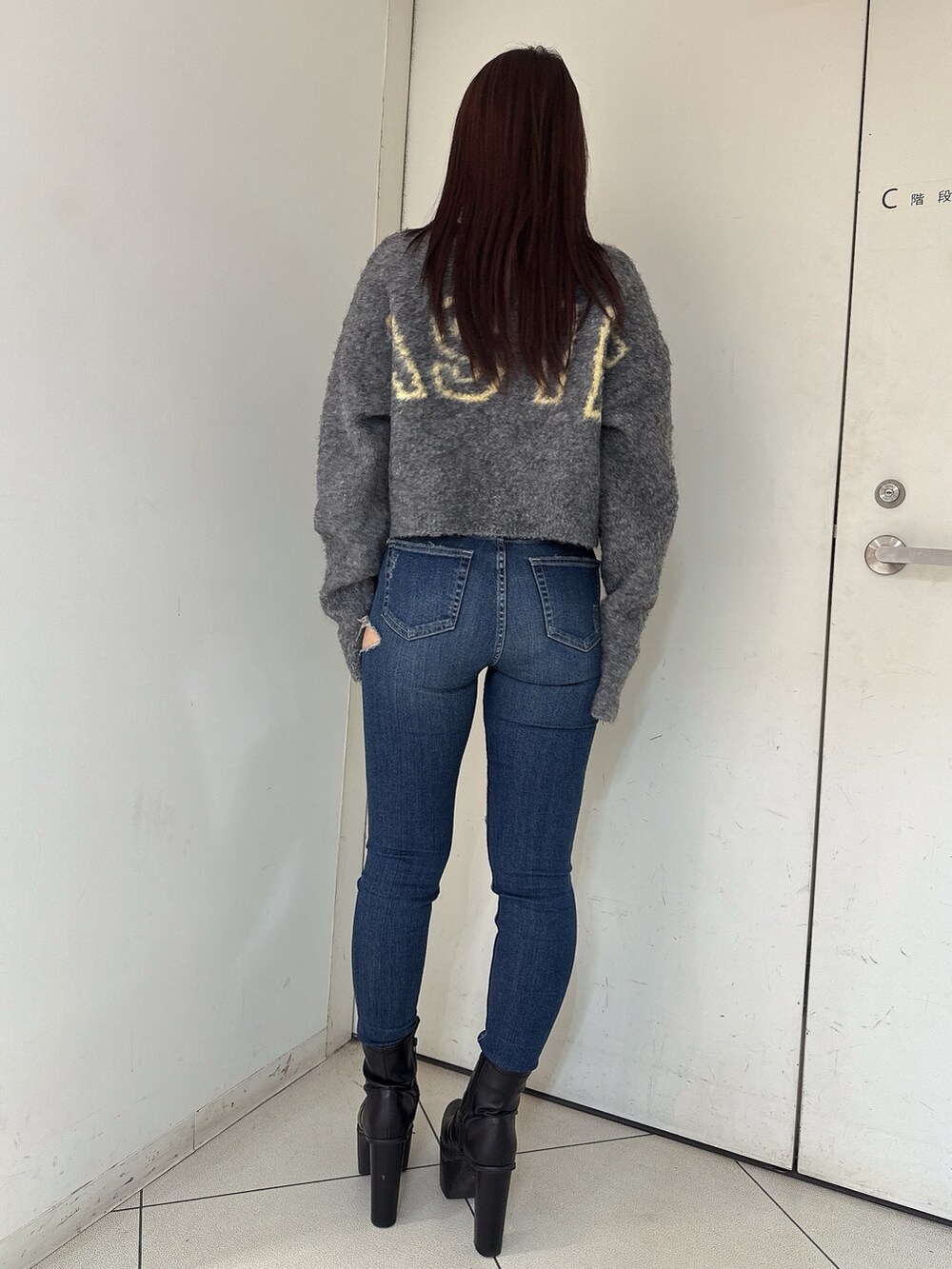 グレー系のカーディガン/ボレロ、ブルー系のデニムパンツ、ブラック系のブーツを着用したレディースの秋コーディネートの3枚目の写真