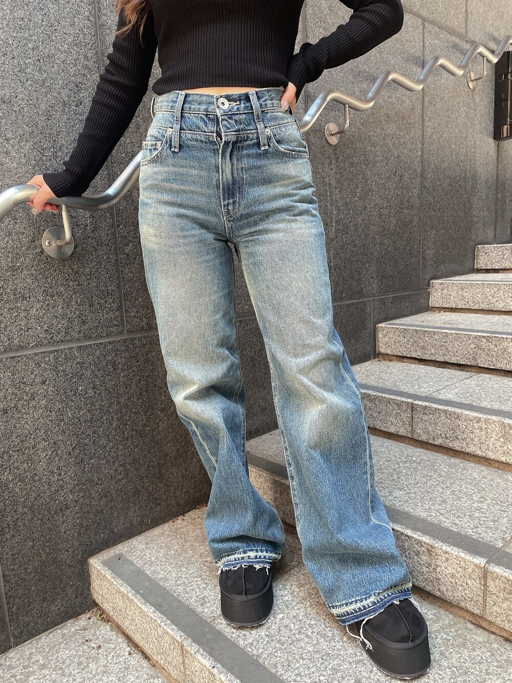 ブラック系のニット/セーター、ブルー系のデニムパンツ、ブラック系のスリッポンを着用したレディースの秋コーディネートの8枚目の写真