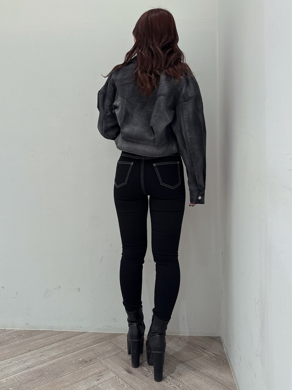 ブラック系のテーラードジャケット、グレー系のニット/セーター、ブラック系のデニムパンツを着用したレディースの冬コーディネートの3枚目の写真