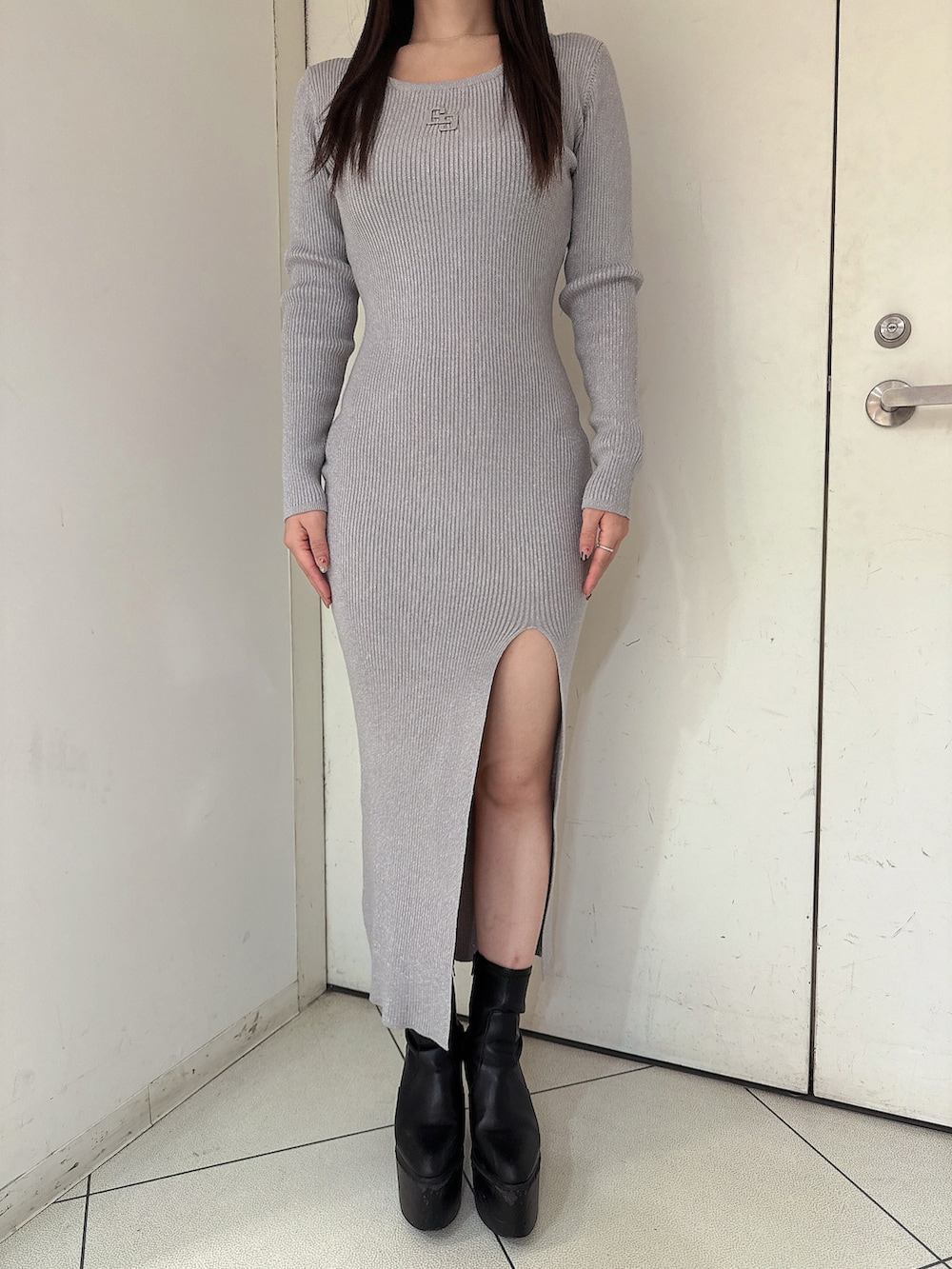 シルバー系のワンピース、ブラック系のライダースジャケット、ブラック系のブーツを着用したレディースの冬コーディネートの8枚目の写真