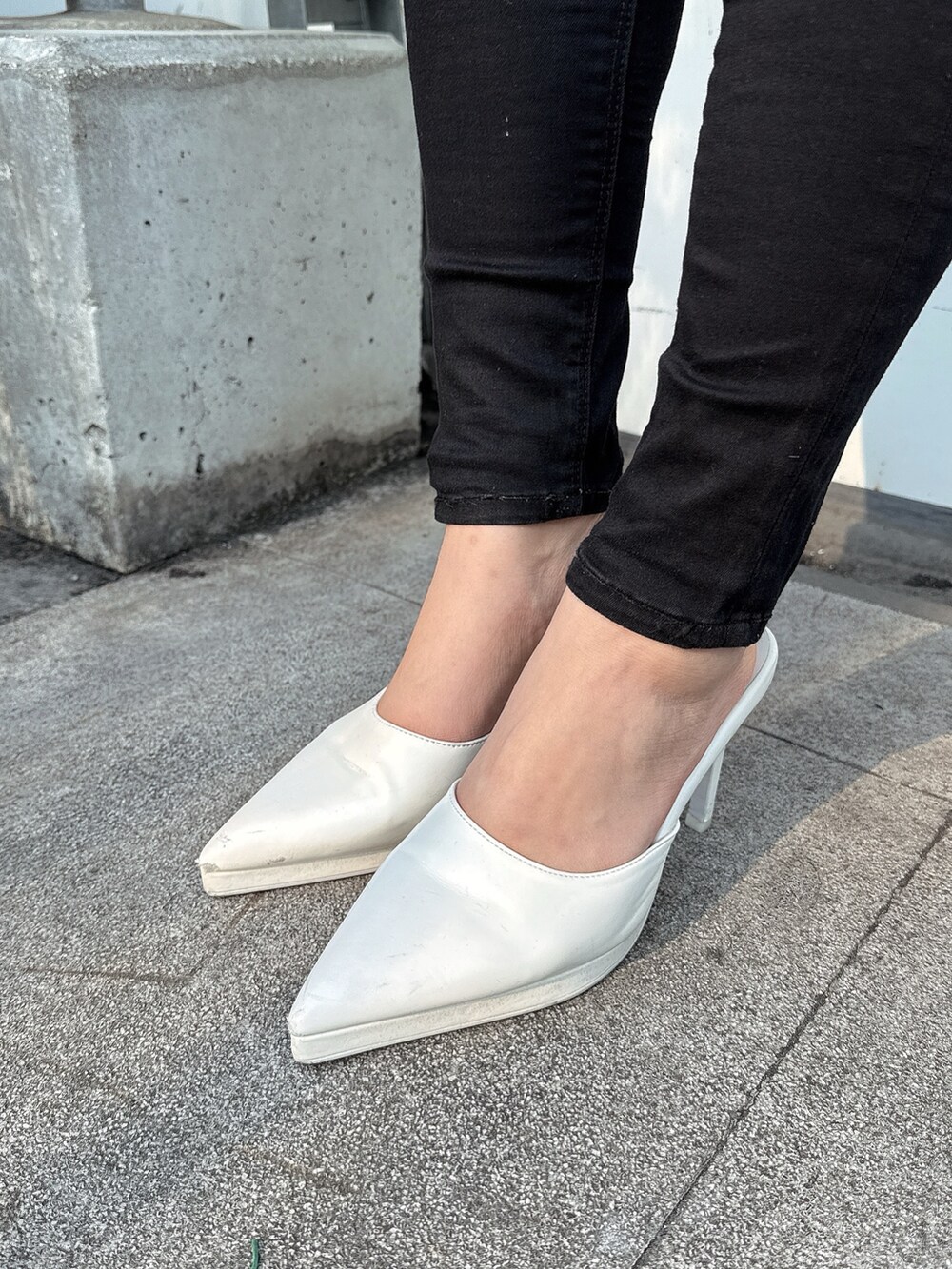 ブルー系のニット/セーター、ブラック系のデニムパンツ、ホワイト系のパンプスを着用したレディースの春コーディネートの9枚目の写真