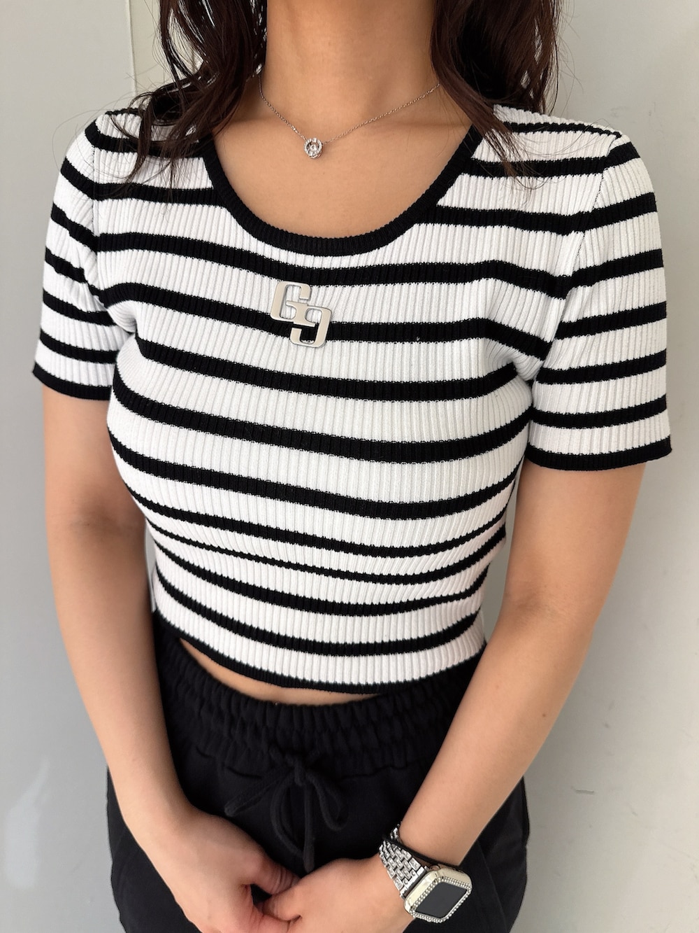 ブラック系のスウェットパンツ、ホワイト系のスニーカー、ブラック系のニット/セーターを着用したレディースの春コーディネートの7枚目の写真