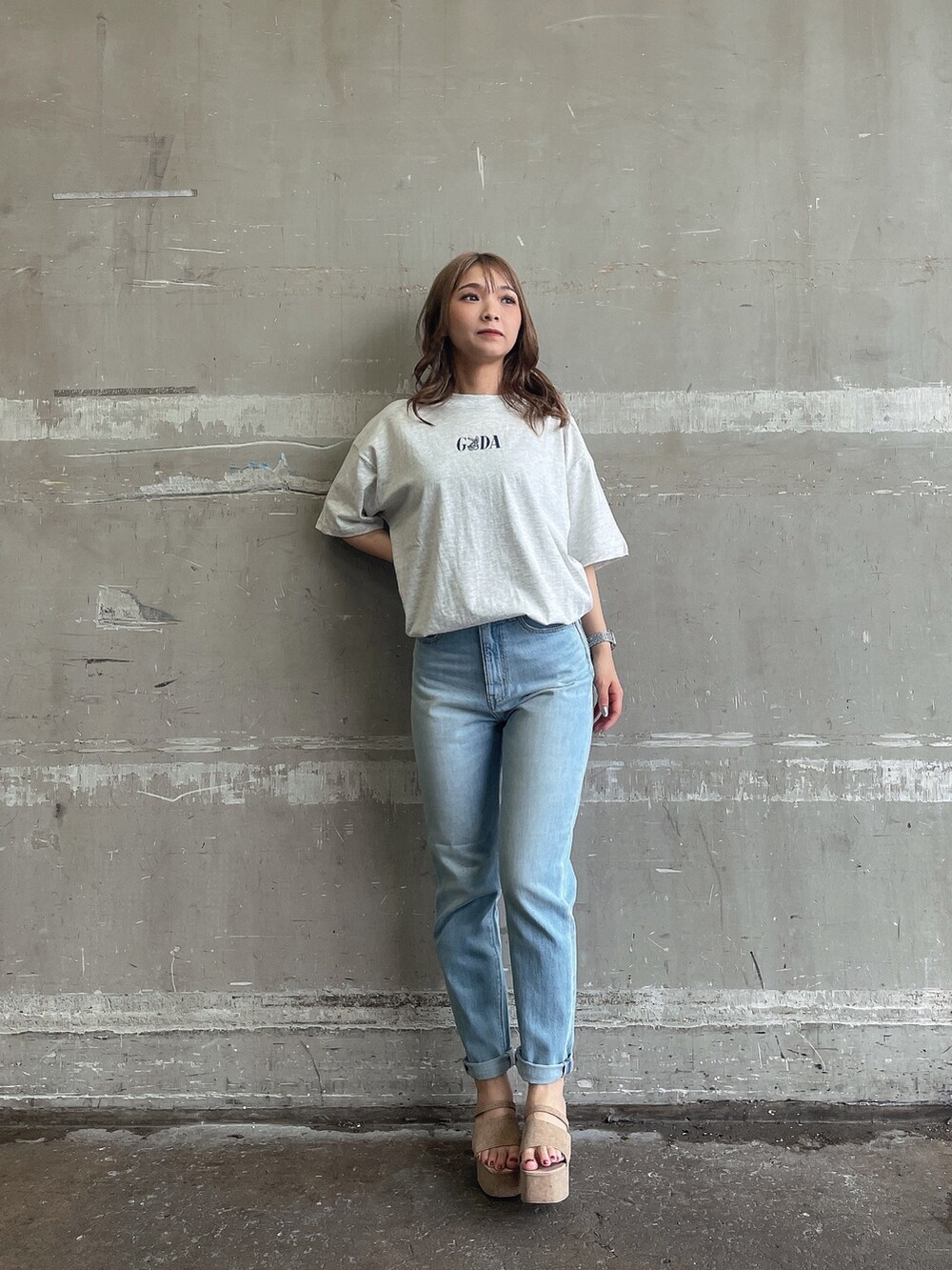 ブルー系のデニムパンツ、ホワイト系のサンダル、グレー系のTシャツ/カットソーを着用したレディースの夏コーディネートの2枚目の写真