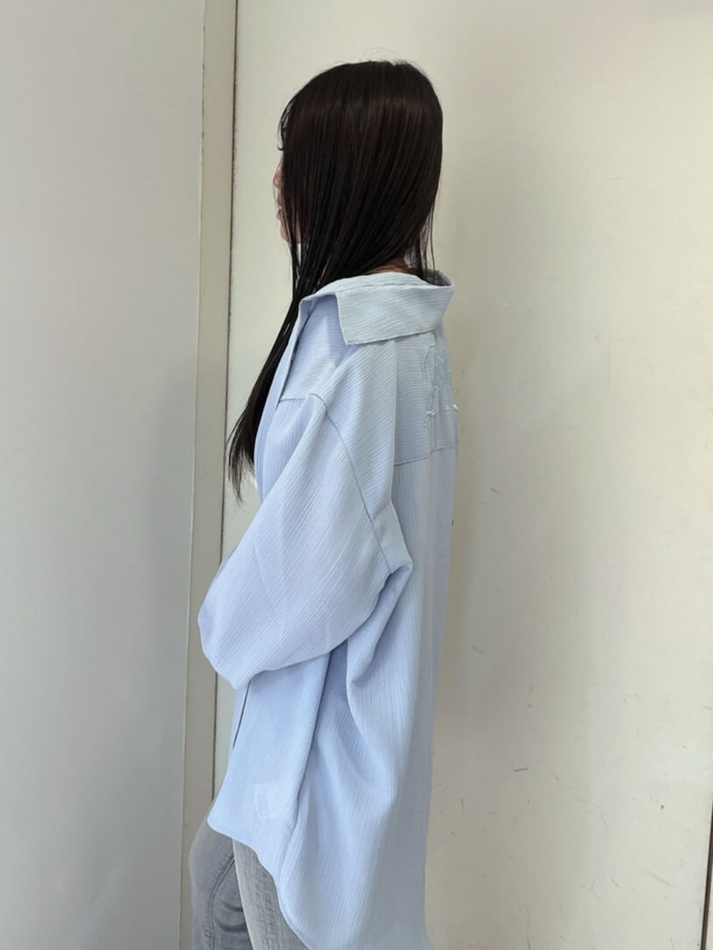ブルー系のデニムパンツ、ブラック系のサンダル、ホワイト系のキャミソールを着用したレディースの春コーディネートの5枚目の写真