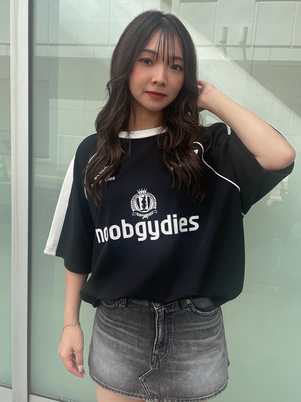 ブラック系のデニムスカート、ブラック系のTシャツ/カットソー、ブラック系のサンダルを着用したレディースの夏コーディネートの4枚目の写真