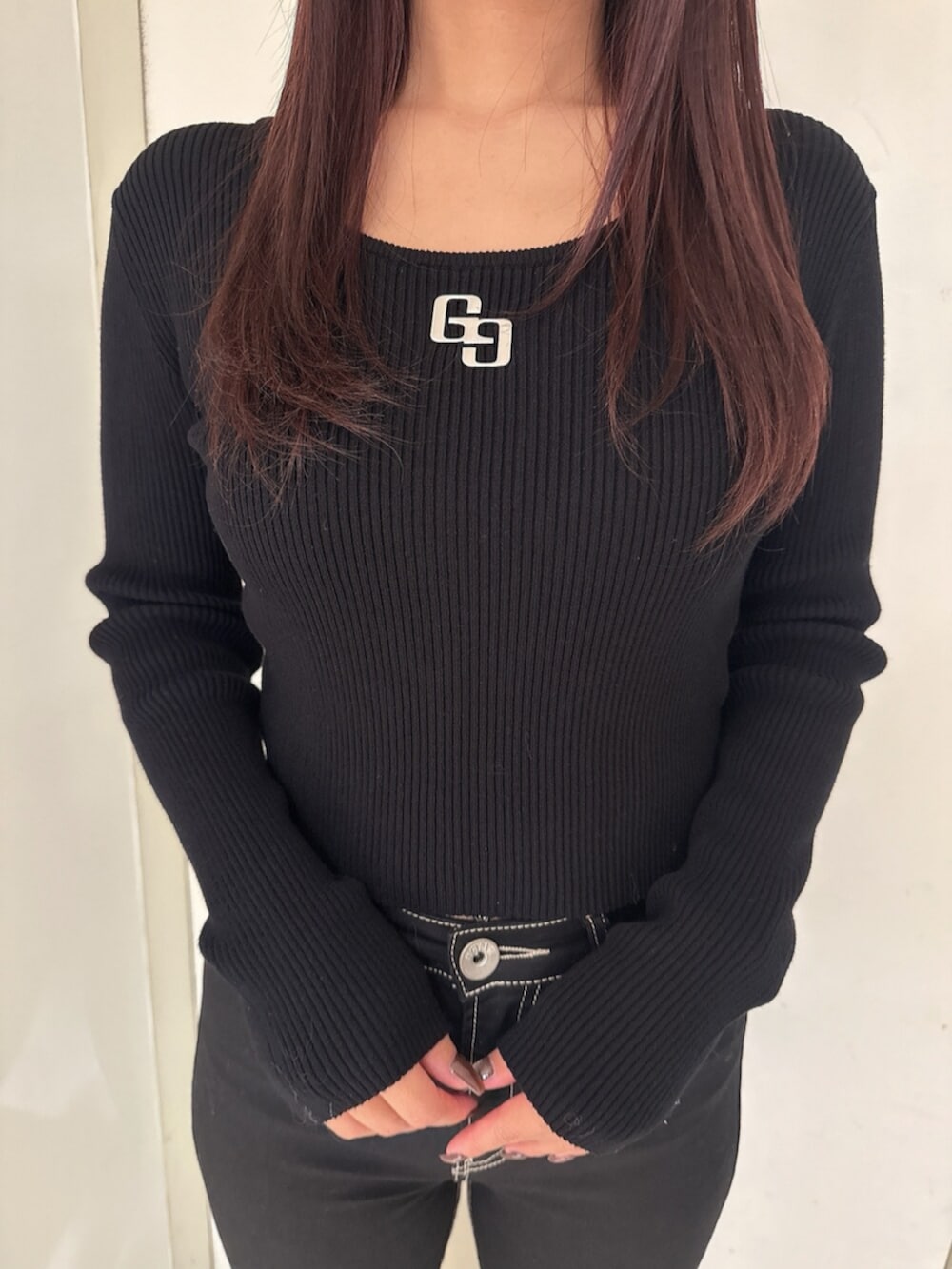 ブラック系のデニムパンツ、ブラック系のニット/セーター、ベージュ系のスタジャンを着用したレディースの秋コーディネートの9枚目の写真