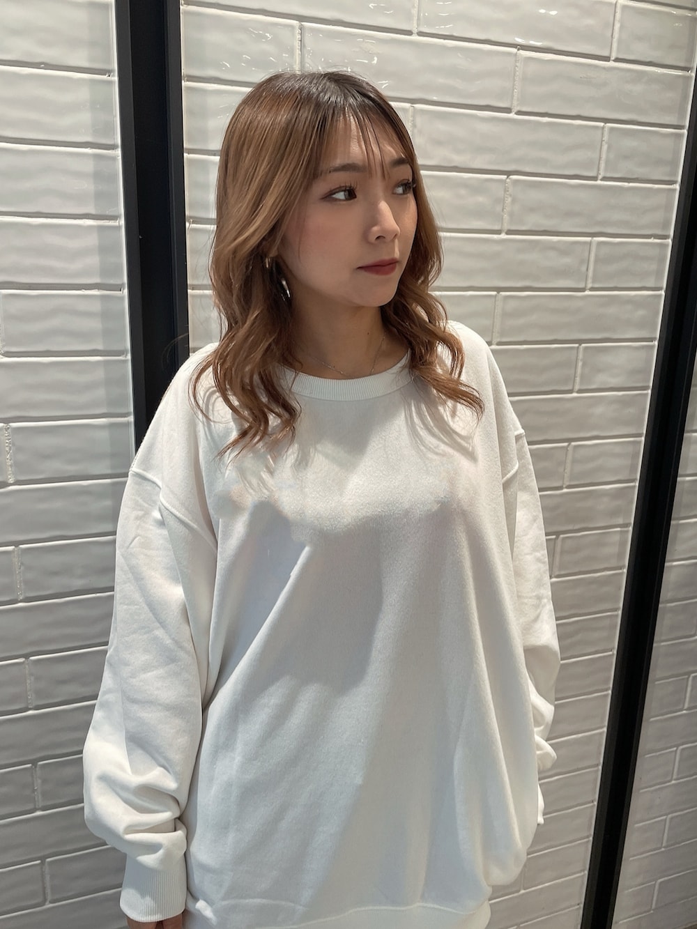 ホワイト系のTシャツ/カットソー、ホワイト系のバックパック/リュック、ブルー系のデニムパンツを着用したレディースの冬コーディネートの6枚目の写真