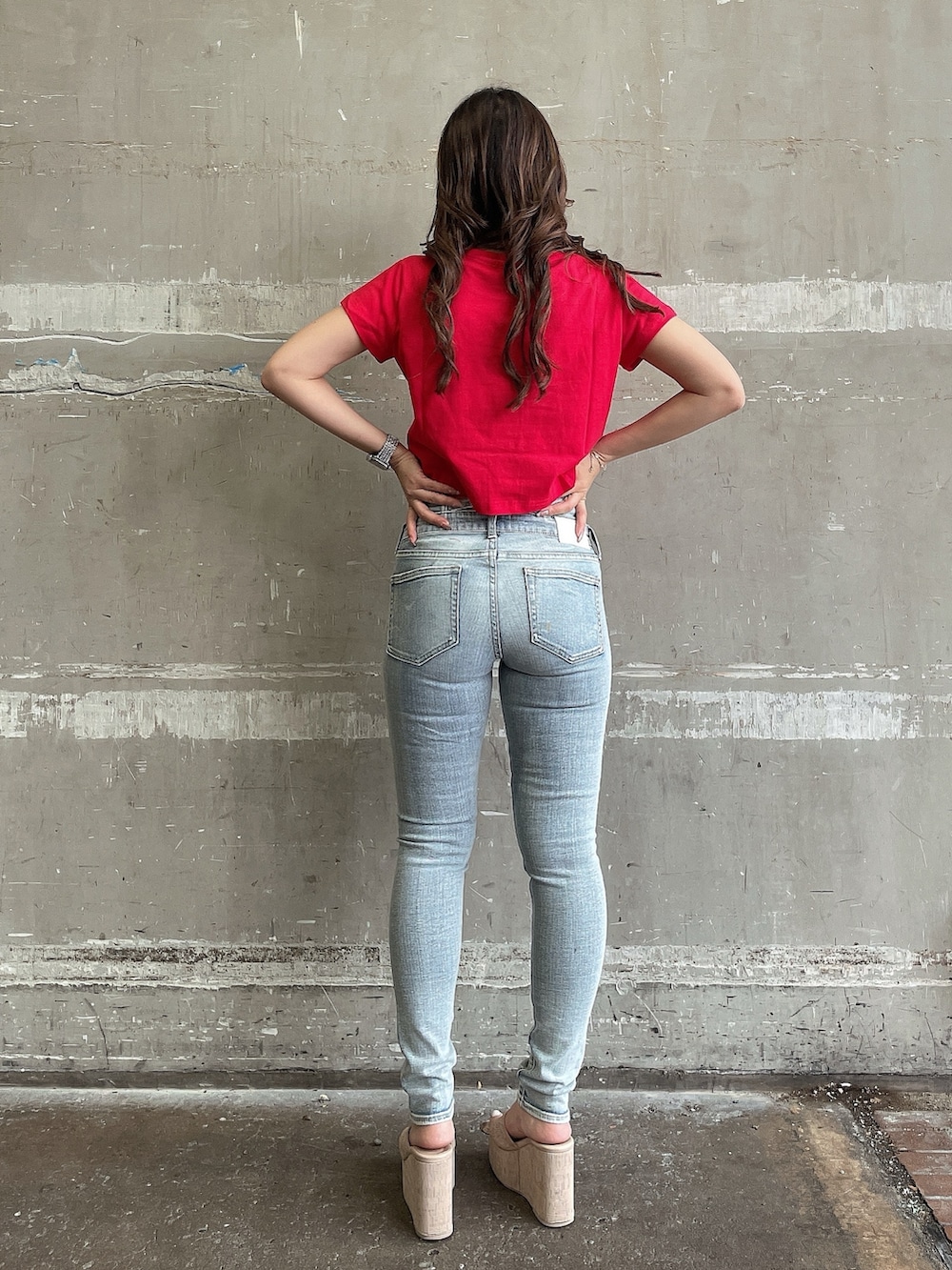 レッド系のTシャツ/カットソー、ブルー系のデニムパンツ、ホワイト系のサンダルを着用したレディースの夏コーディネートの3枚目の写真