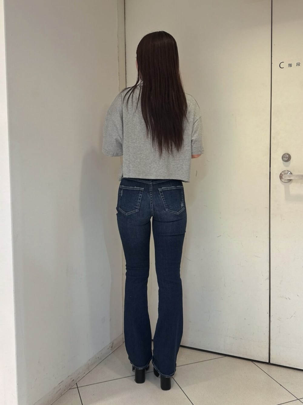 ブルー系のデニムパンツ、ブラック系のサンダル、グレー系のTシャツ/カットソーを着用したレディースの夏コーディネートの3枚目の写真