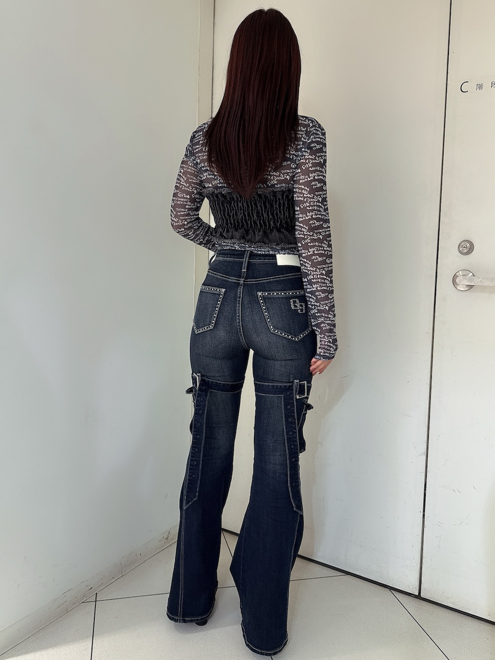 ブルー系のデニムパンツ、ブラック系のブーツ、ブラック系のTシャツ/カットソーを着用したレディースの夏コーディネートの3枚目の写真
