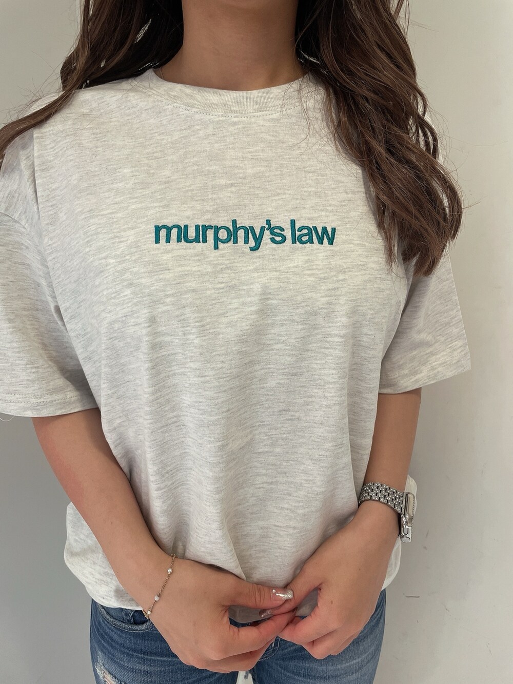 グレー系のTシャツ/カットソー、ブルー系のデニムパンツ、ホワイト系のサンダルを着用したレディースの夏コーディネートの7枚目の写真